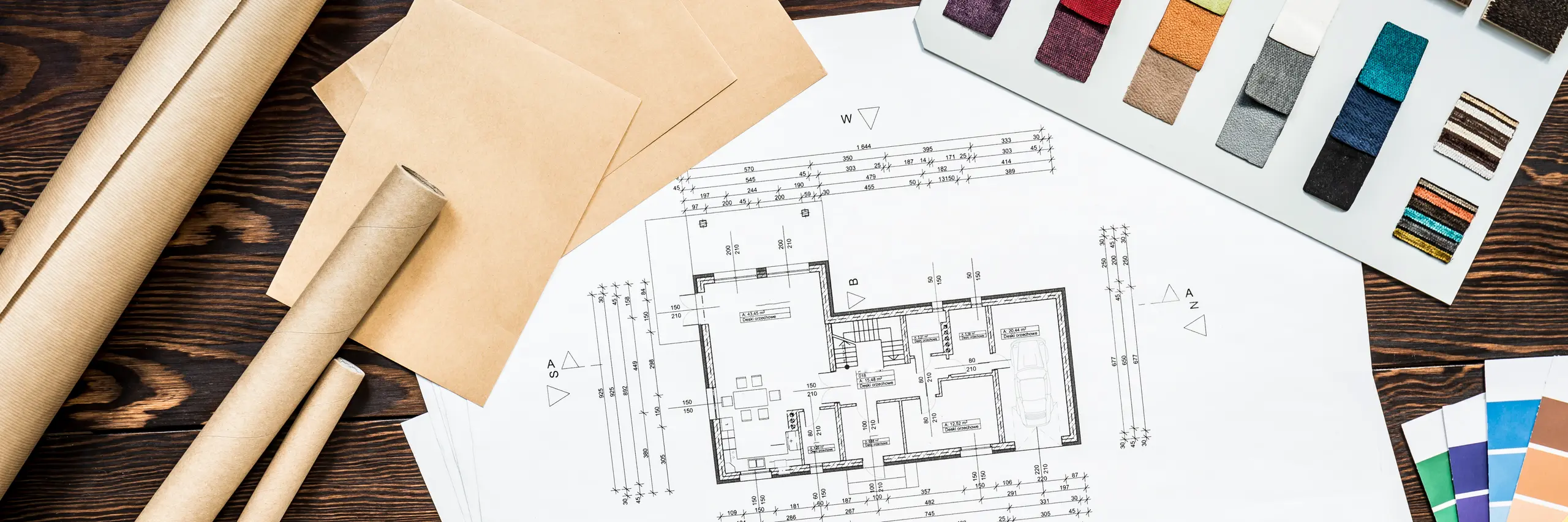 Plan mieszkania z próbkami materiałów i papierowymi rolkami – Projektowanie kuchni