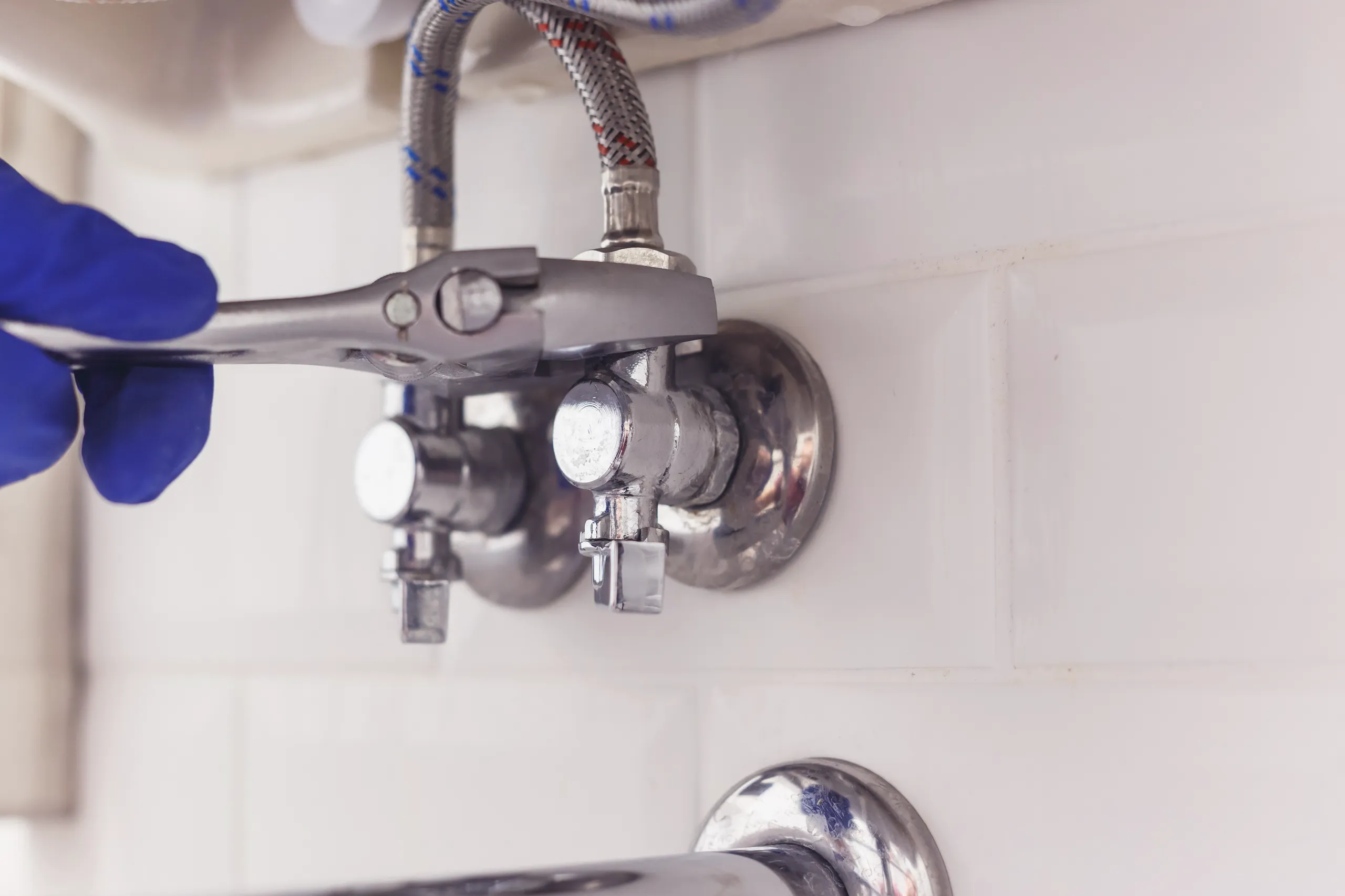 Hydraulika regulacja zaworów wodnych pod umywalką za pomocą klucza nastawnego